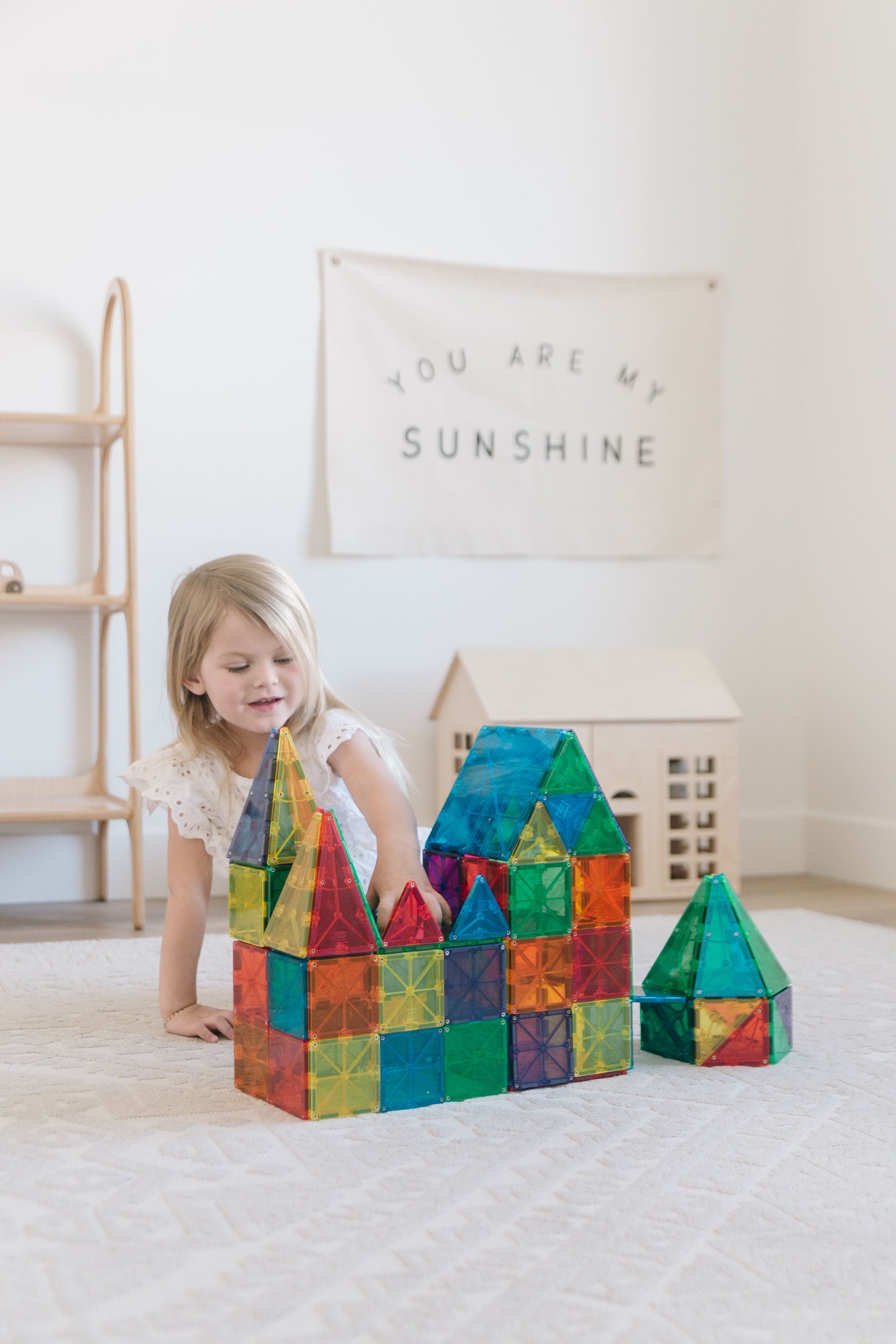 Magna-Tiles Classic durchsichtige Magnetfliesen, von einem kleinen Kind zu einer bunten Struktur zusammengebaut
