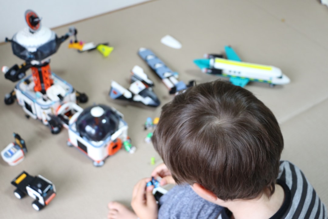 Child playing with space-themed toys on the floor.